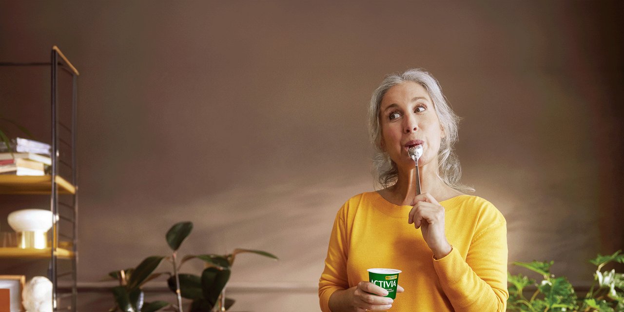 Ältere Dame ist einen Activia Joghurt