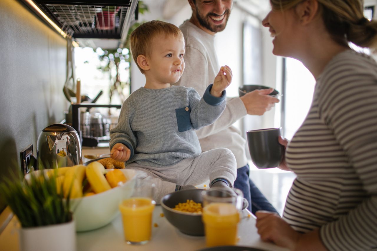 Photo of a young family showing their hectic lifestyle - having a breakfast in their kitchen with their son