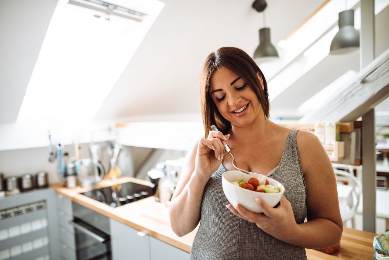 pregnant woman eating healthy food at home