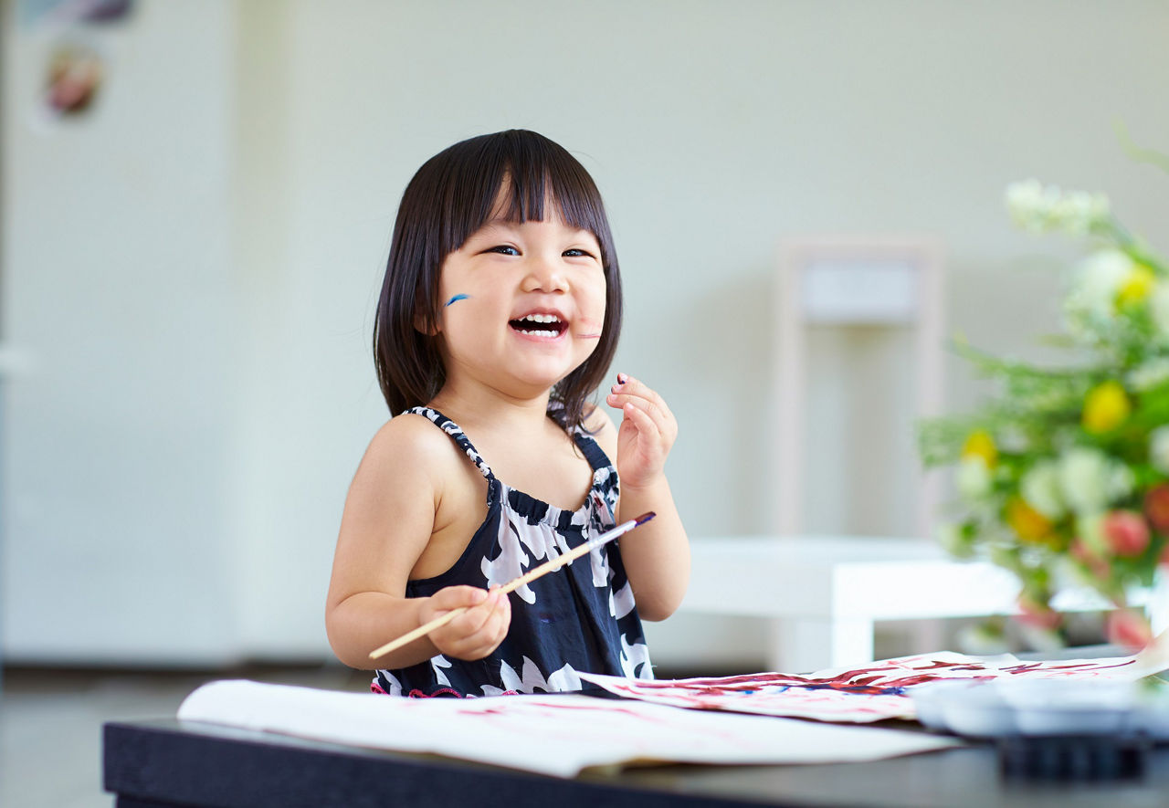 lovely little girl painting in home