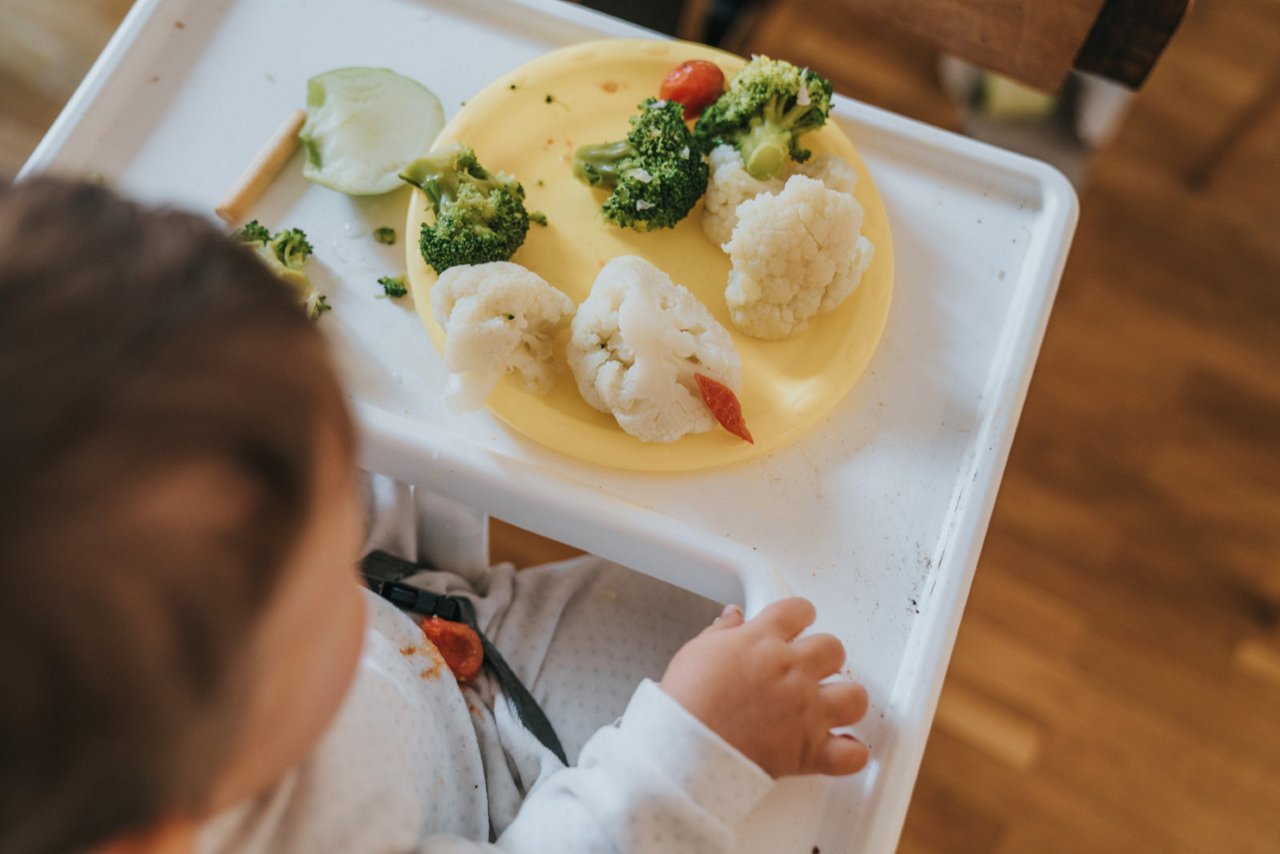 Kinderhand greift Gemüse