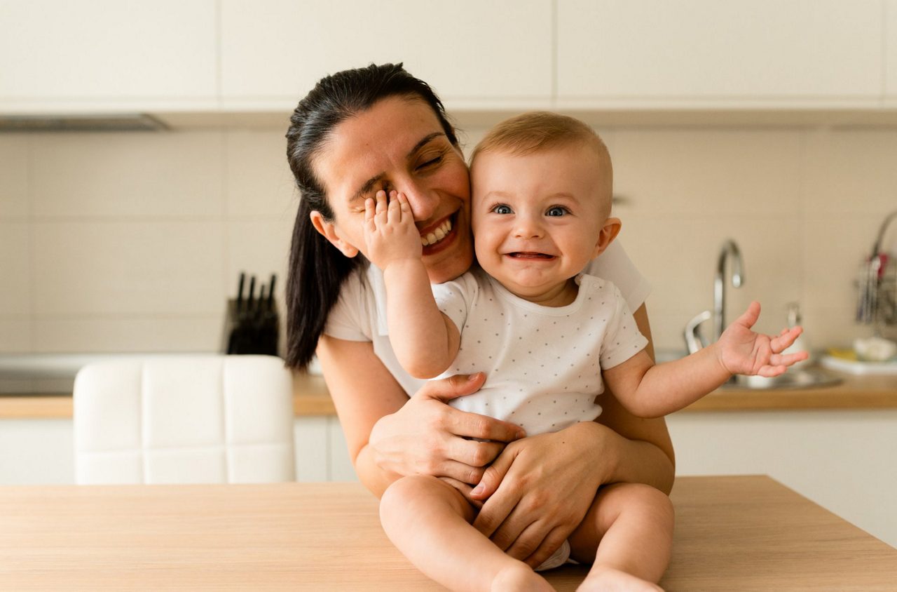 Mutter mit Baby auf der Küchentheke