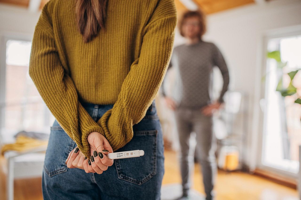 Frau mit positivem Schwangerschaftstest verkündet Mann Schwangerschaft