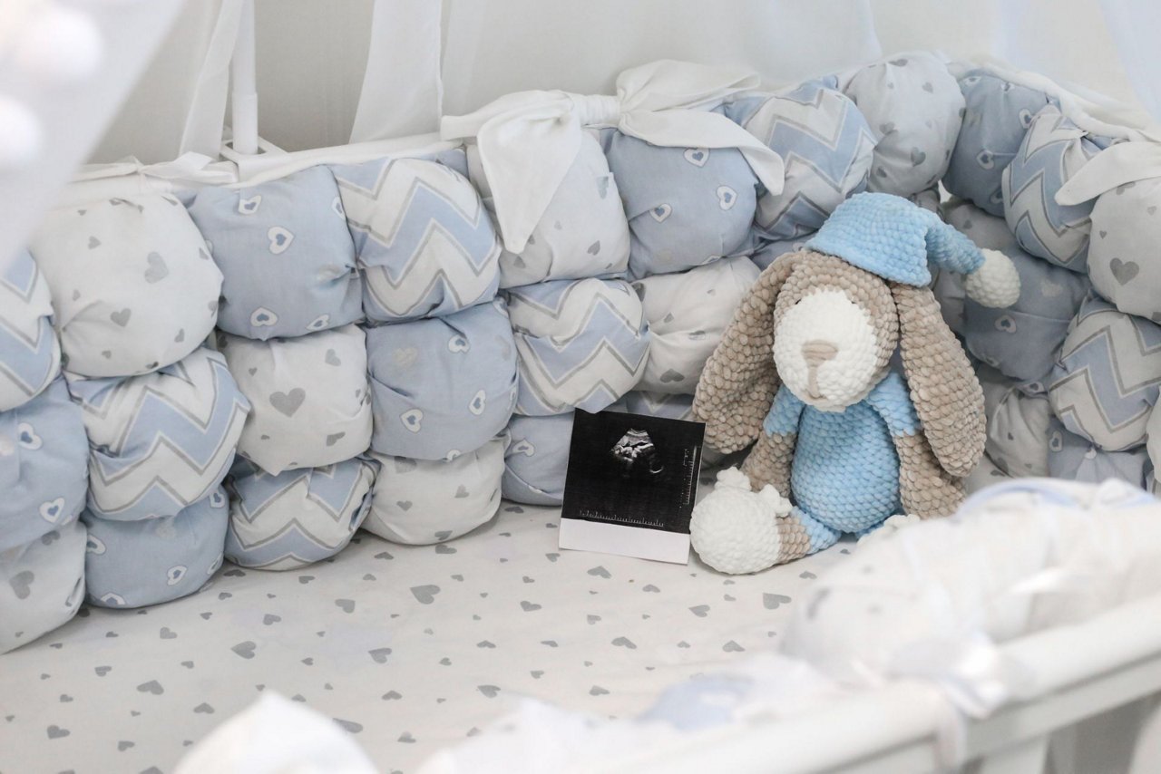 Babybett mit weicher Umrandung und Kuscheltier