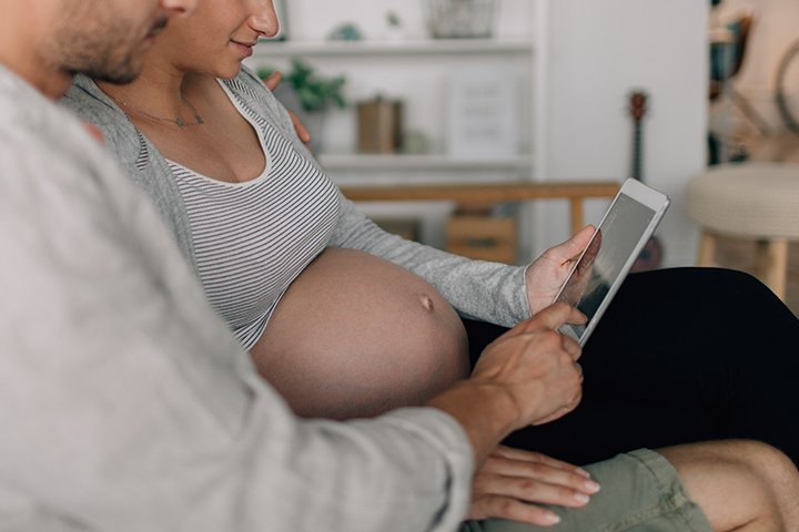 Mama und werdender Papa schauen auf Tablet Livetalk