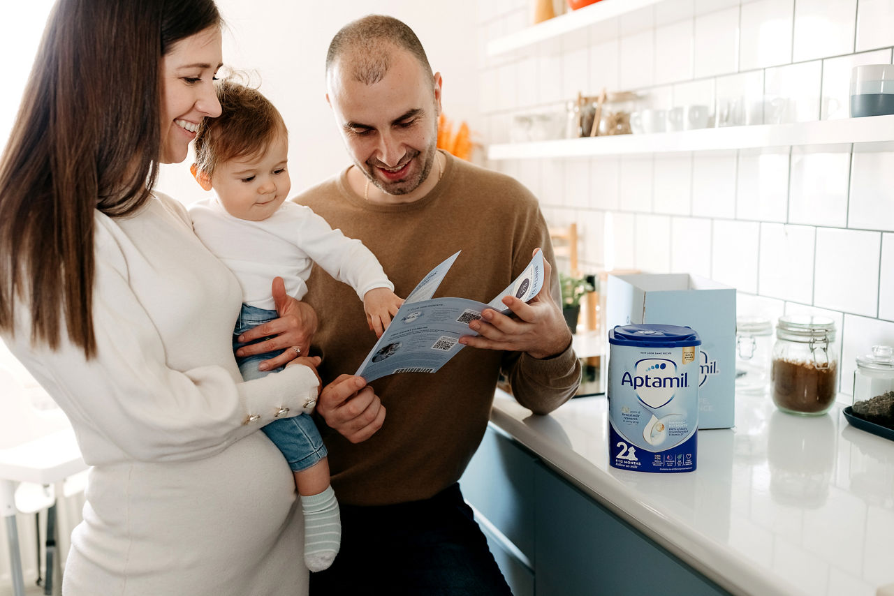 Parents with baby opening Aptamil online order
