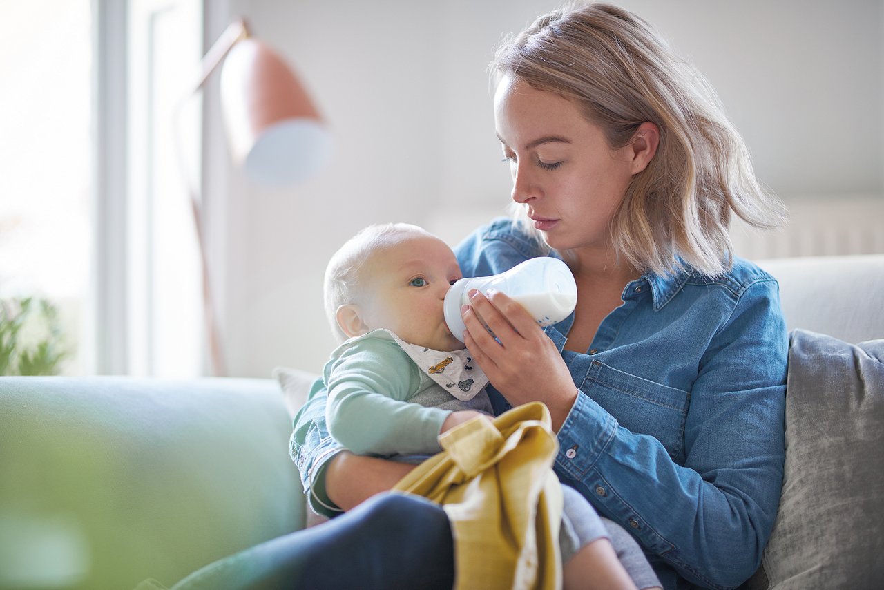 Muutter füttert Baby mit Fläschchen