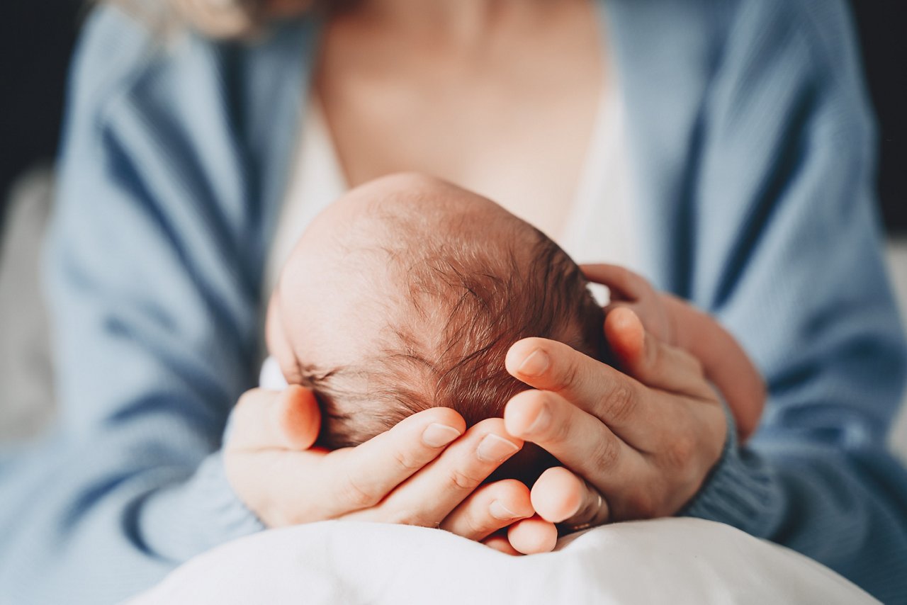 Mama haelt Baby in der Hand