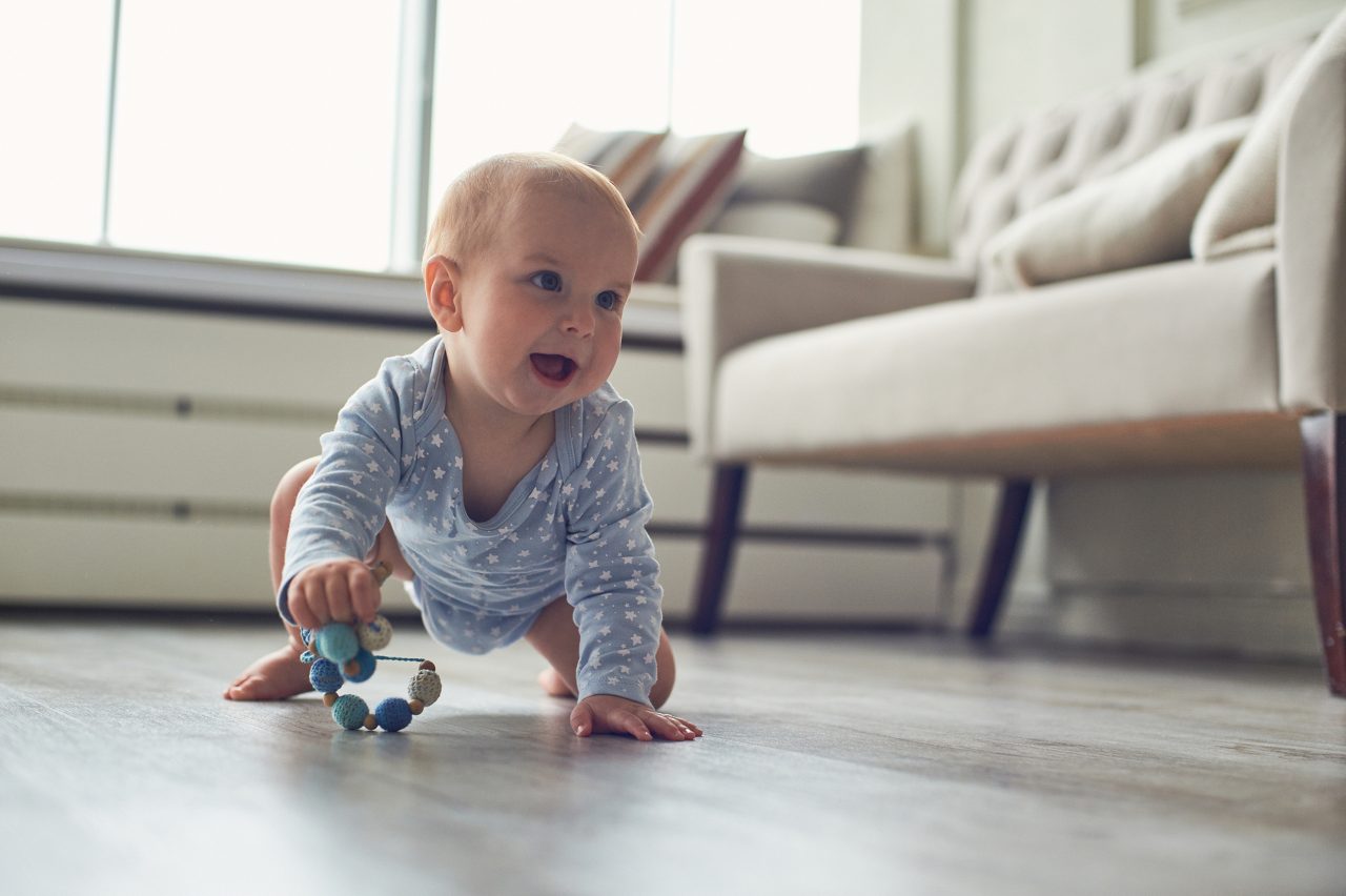 little baby boy crawling on floor at home.