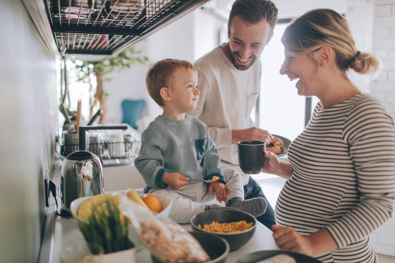 Une femme enceinte fait la cuisine avec son fils