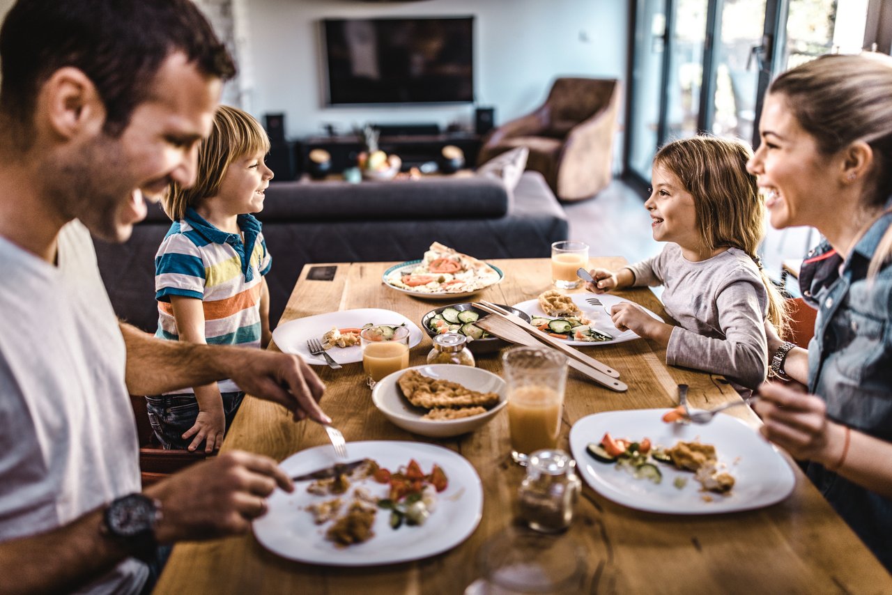 Familie mit Baby beim Essen am Tisch