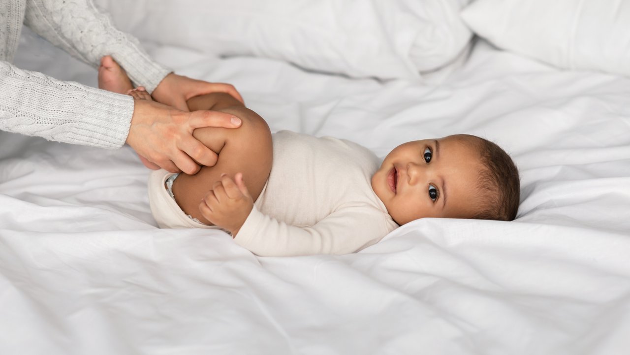 Father holding baby standing in childs bedroom