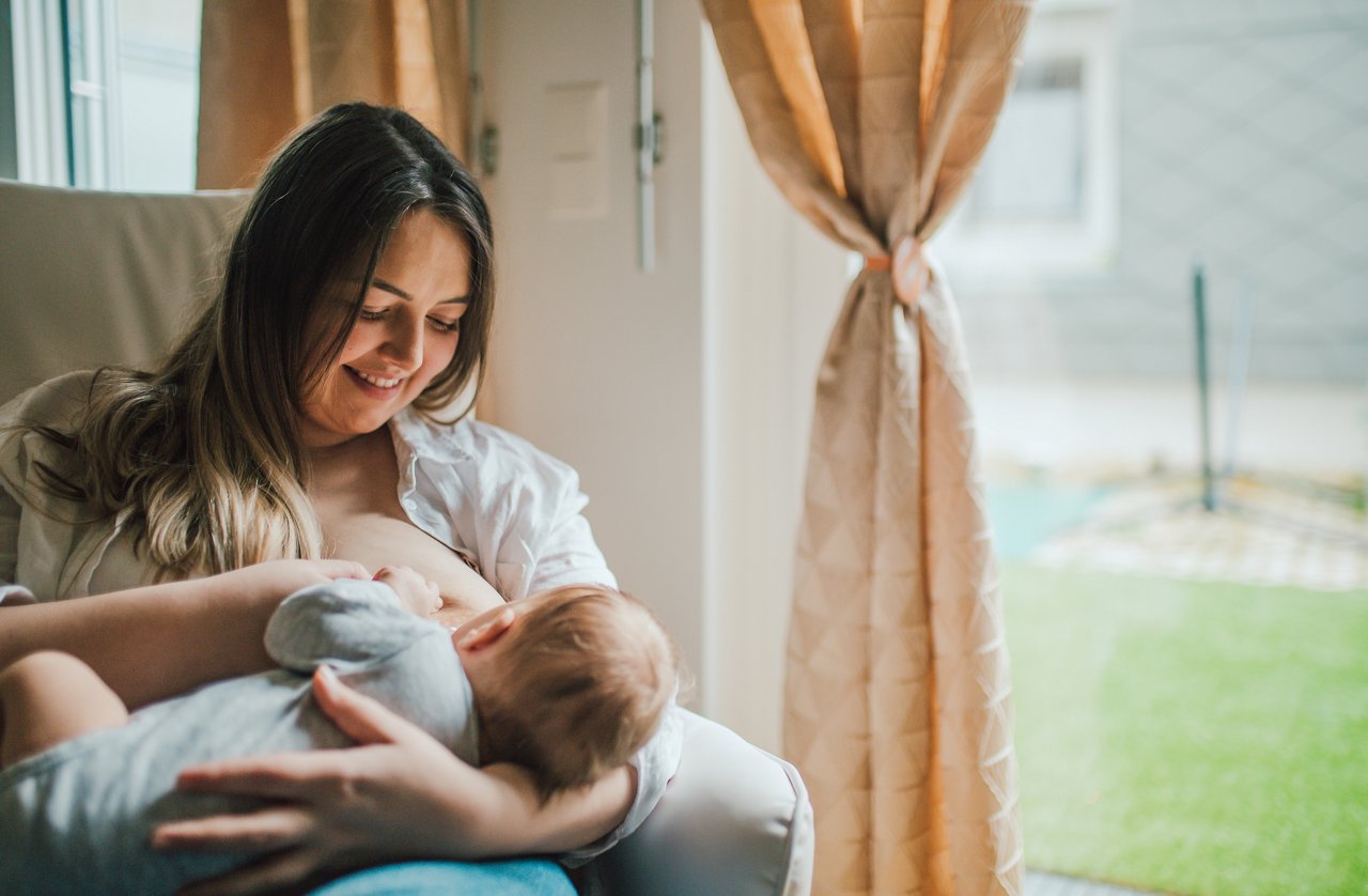 Mother sitting and breastfeeding her baby