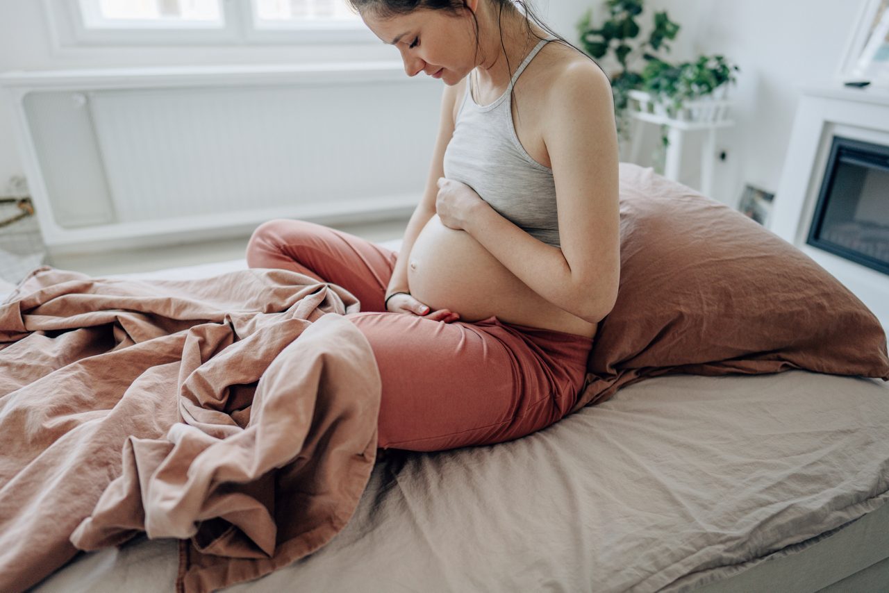 Une femme enceinte tient son ventre arrondi