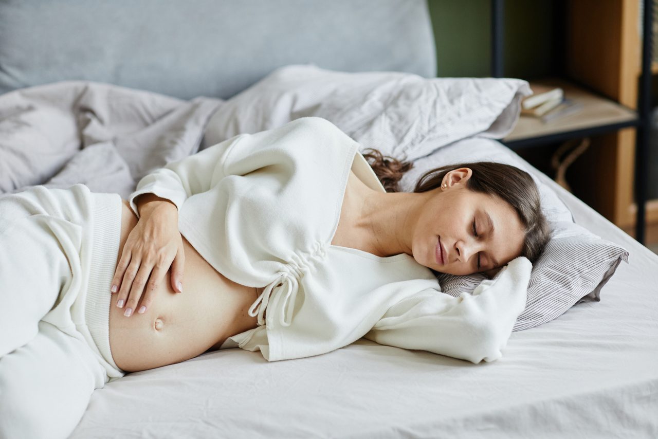 Femme enceinte allongée sur un sofa