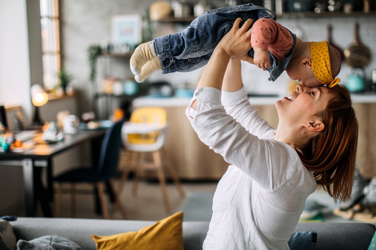 Mother playing flying games with her baby girl
