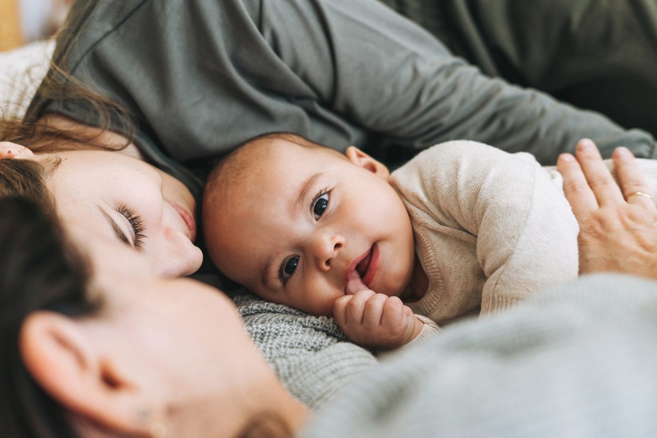 Baby die brabbelt met zijn ouders, als illustratie van de eerste klanken, taalontwikkeling en vroege communicatie.
