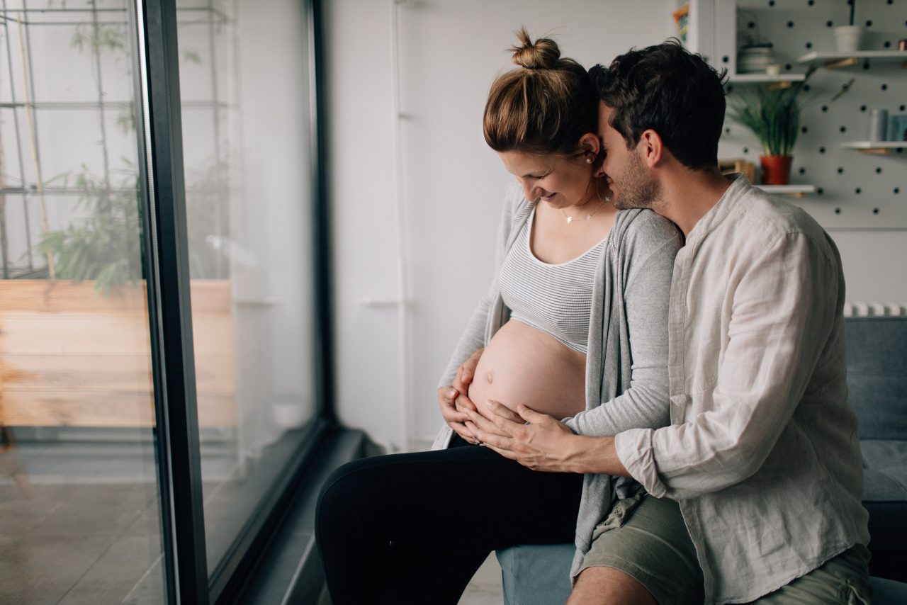 Un papa caresse le ventre d'une future maman.