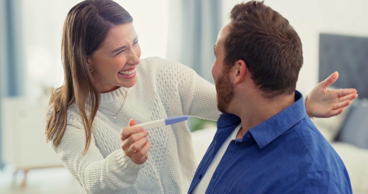 Woman showing man positive pregnancy test