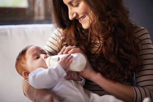 Mutter die ihr Baby mit Schoppen füttert