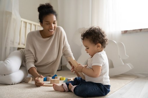 Mother and baby playing in childs room