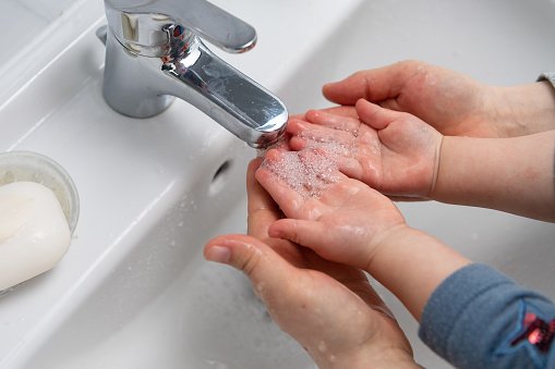 Mutter und Kleinkind waschen sich die Hände