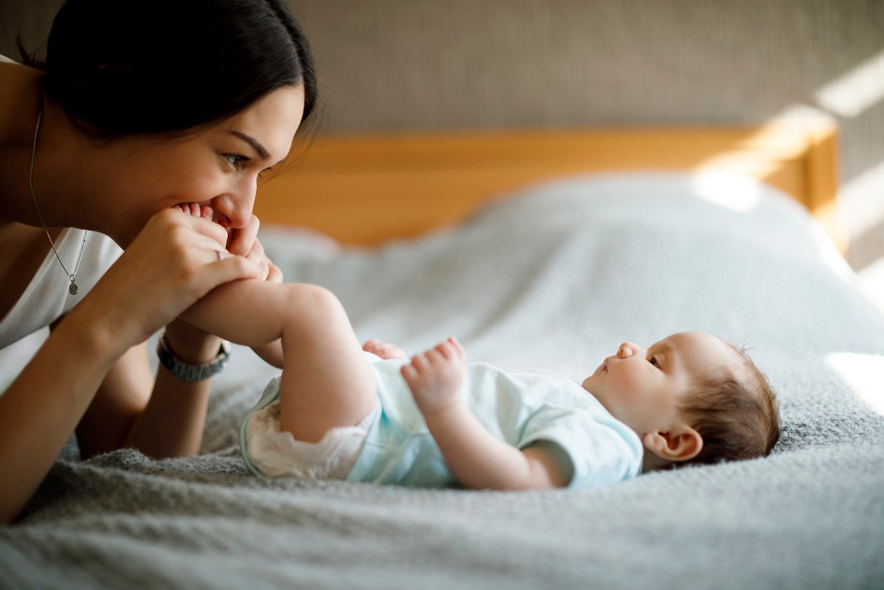 Happy mother playing with her baby