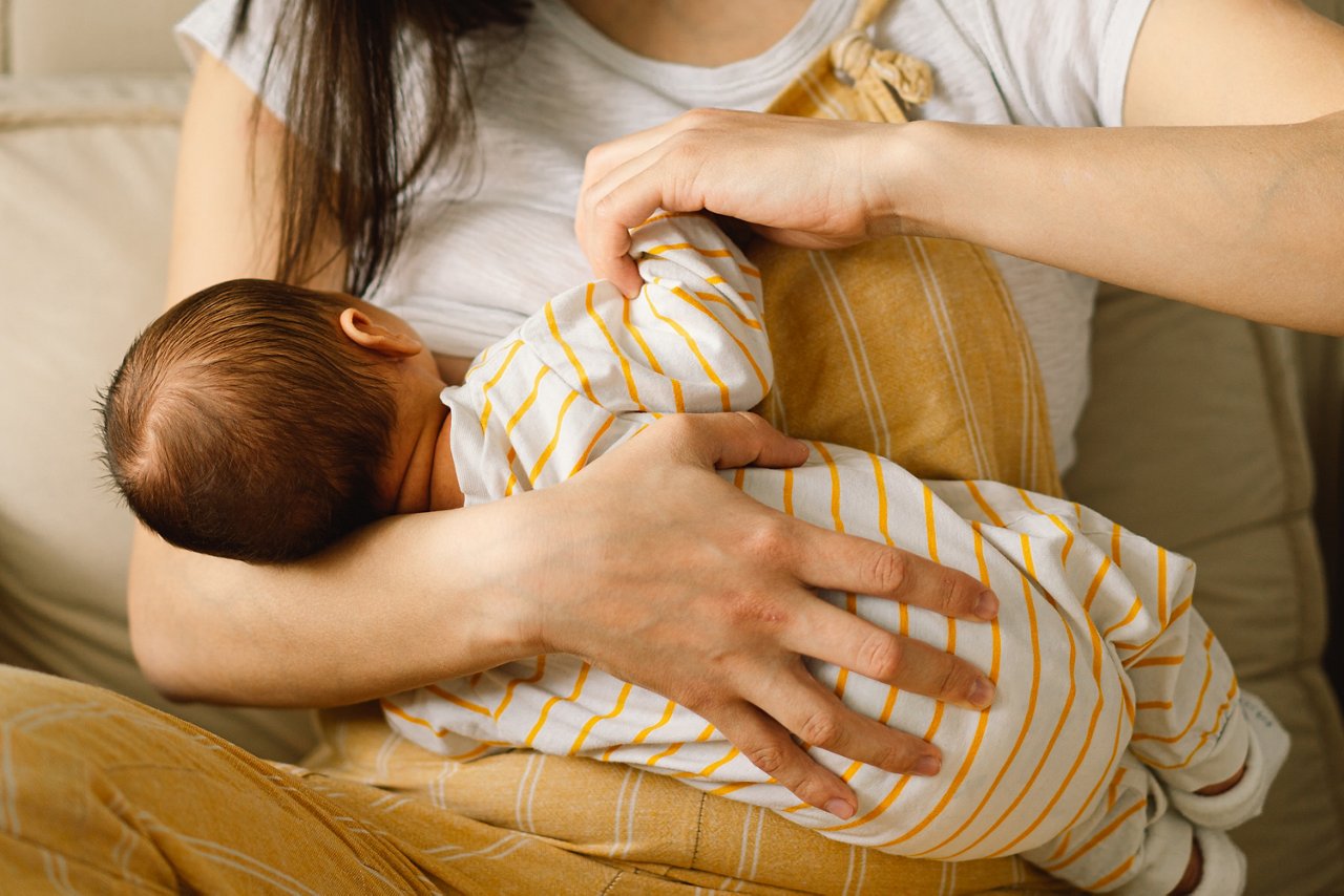 Baby schaut zur Mutter während dem Stillen