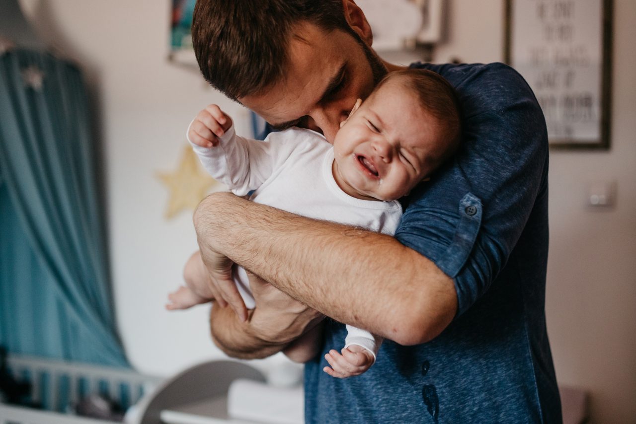 Dad embracing crying baby