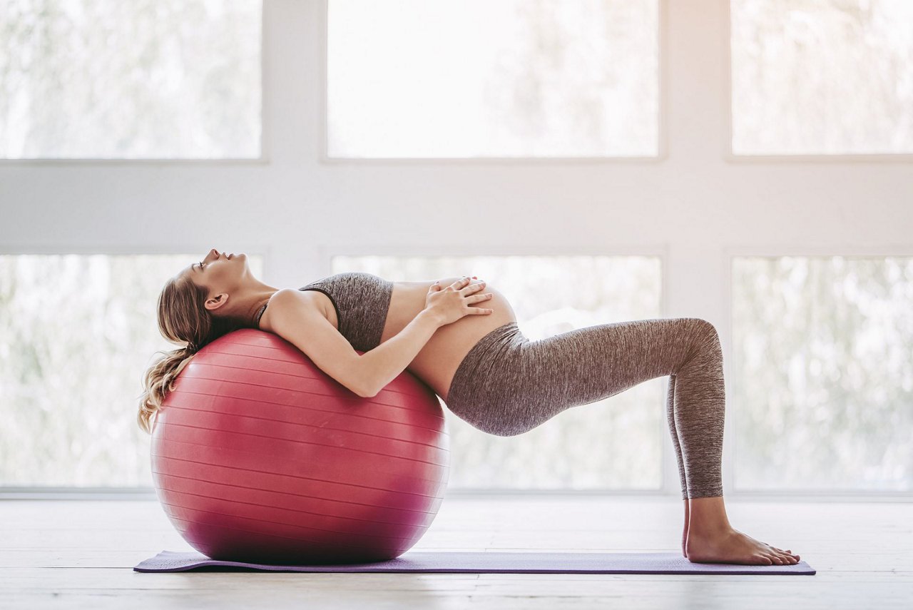 Schwanger macht Sport mit Gymnastikball