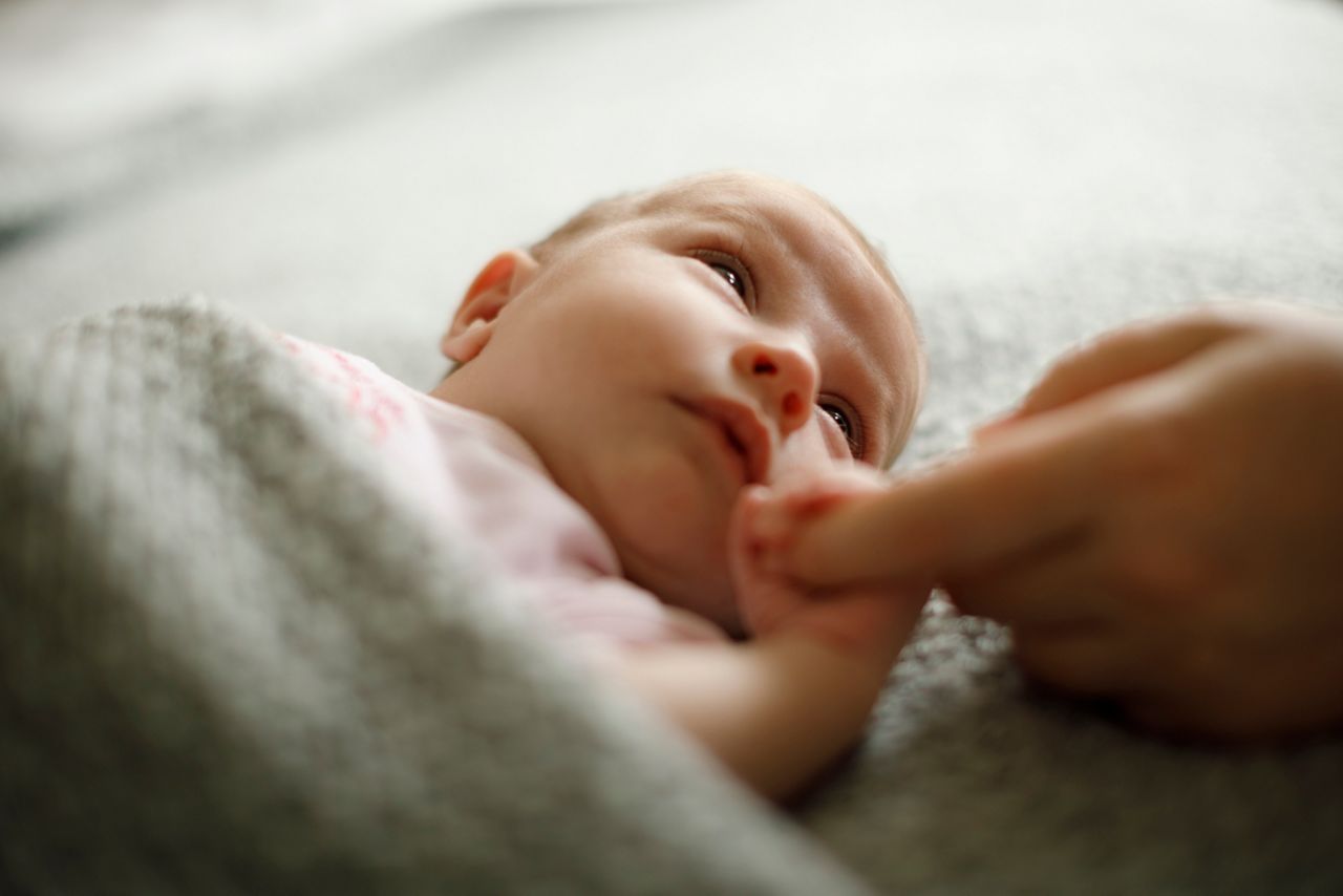 Newborn baby holding mother's hand