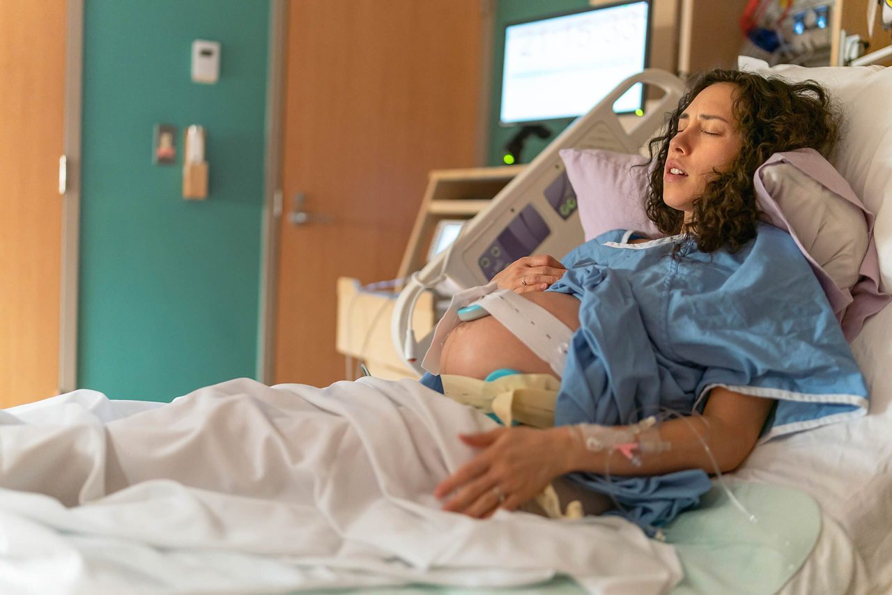 Déroulement de l'accouchement: femme enceinte dans un lit d'hôpital