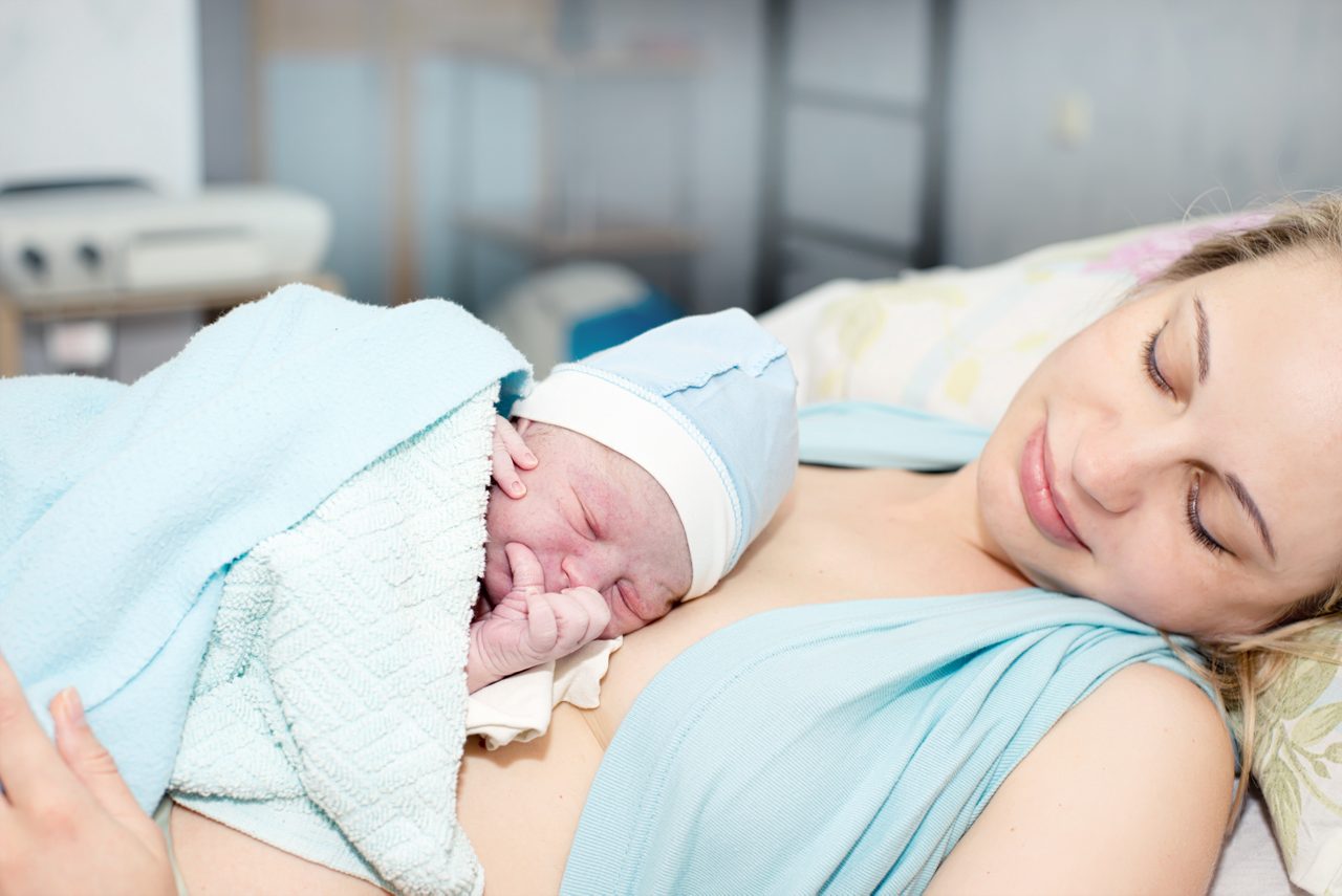 Mutter und Neugeborenes liegen gemeinsam im Bett