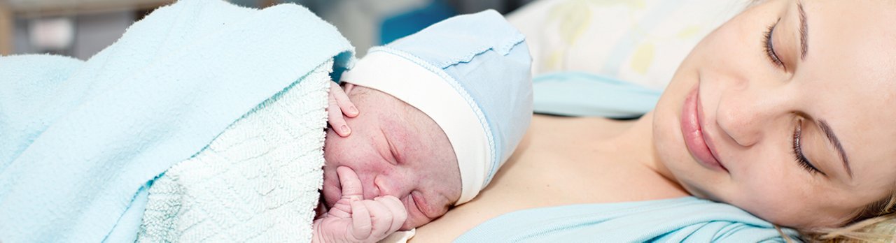 Mutter hält Neugeborenes im Krankenhaus 