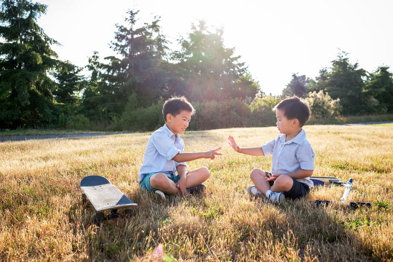 Happy Asian Kids Playing Rock Paper Scissors Outdoor In A Park