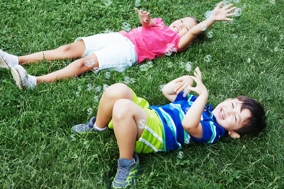 kids laying on the grass
