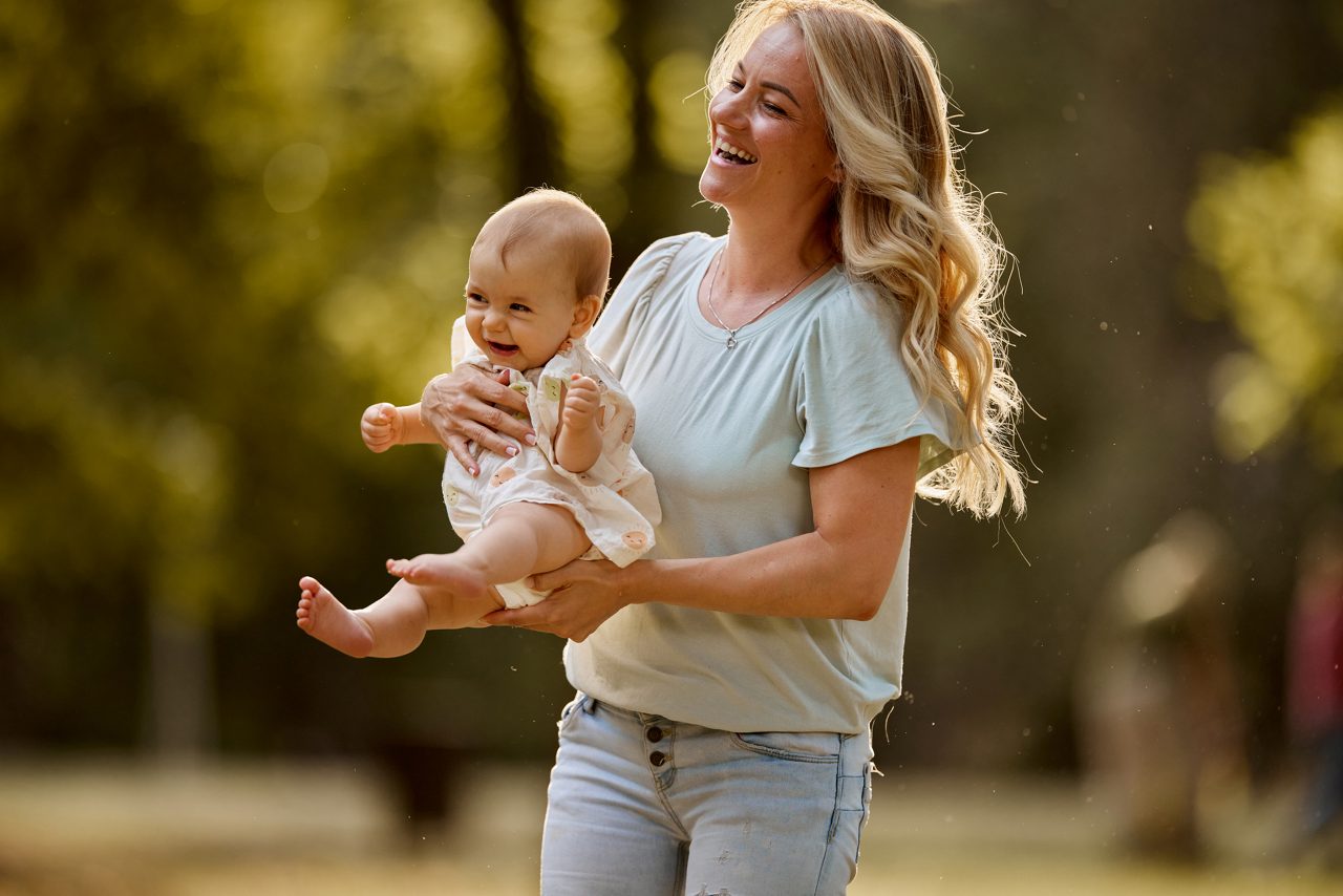 Baby auf dem Arm vom Vater in der Natur