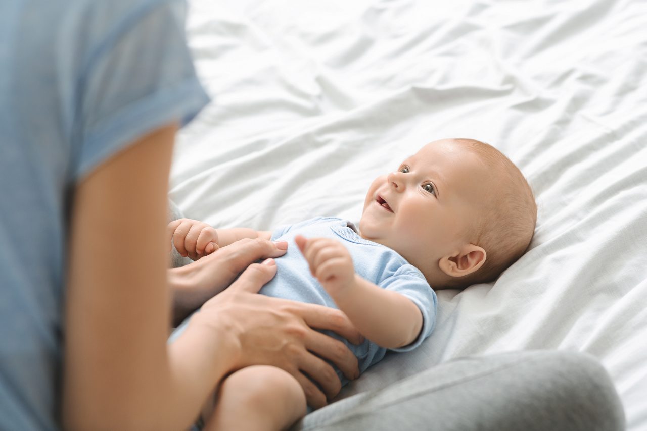 Baby hat kolik und liegt im Arm der Mutter