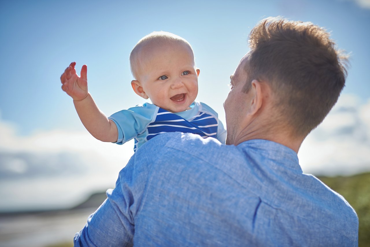 Man holding infant on the beach