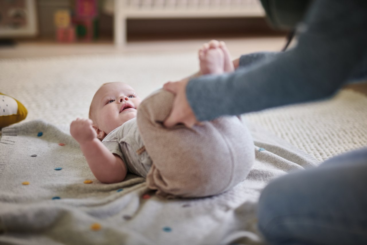 Web only - mum giving leg massage while baby on back