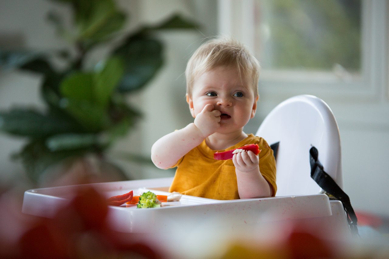 Baby mit Eltern beim Essen am Tisch