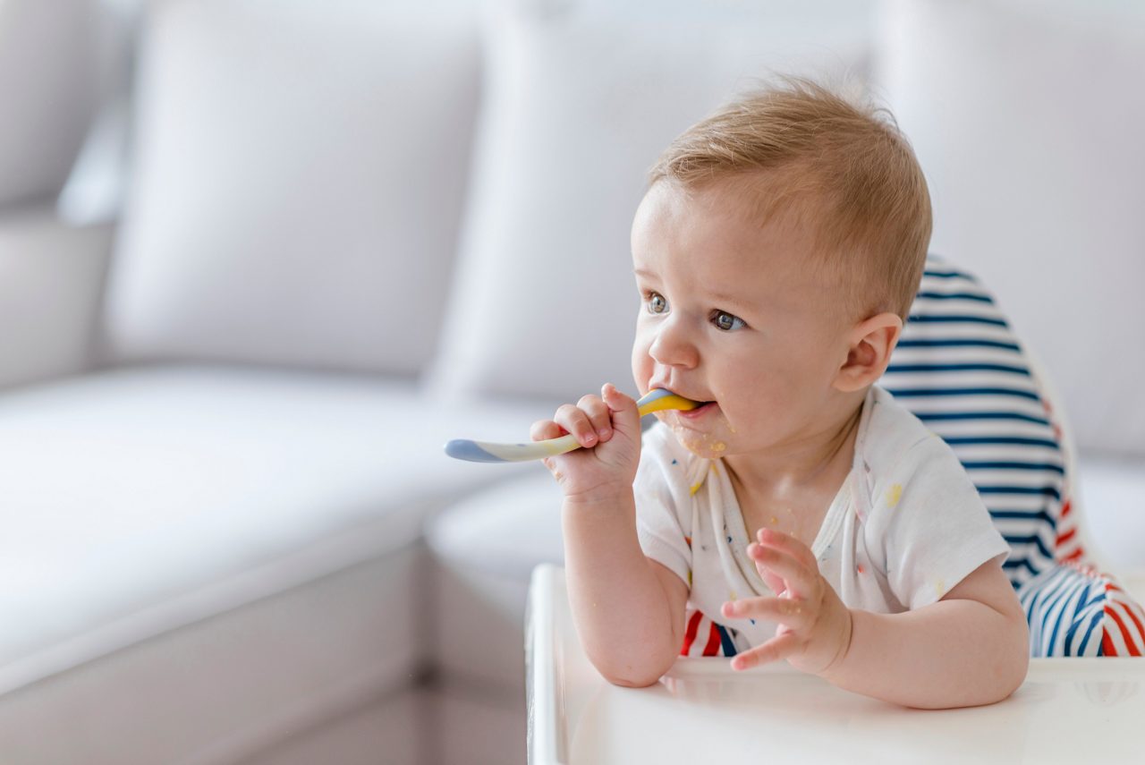 Baby isst Brei mit Löffel