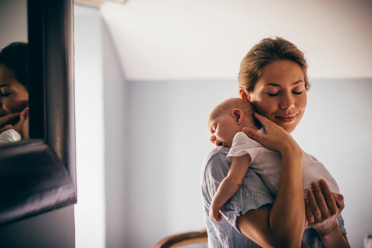 Mutter hilft Baby beim Bäuerchen