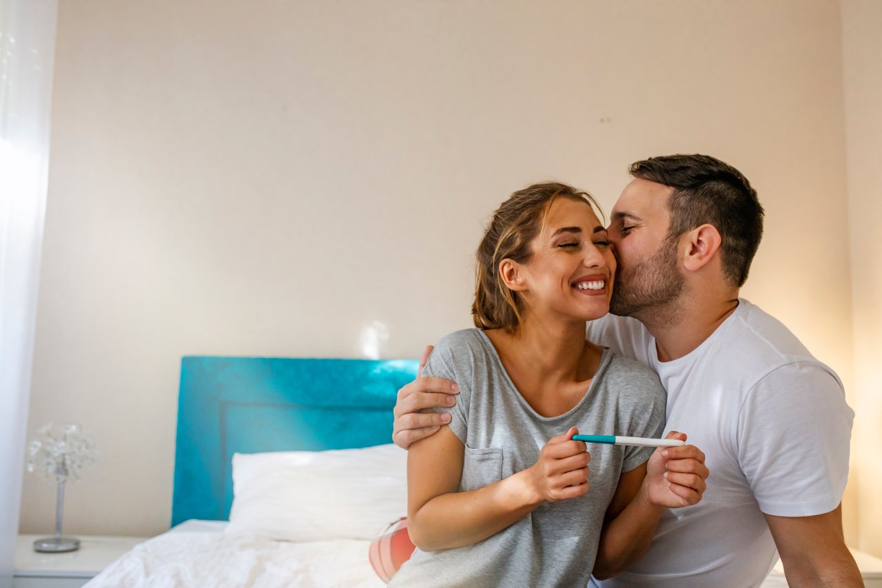 Woman showing man positive pregnancy test