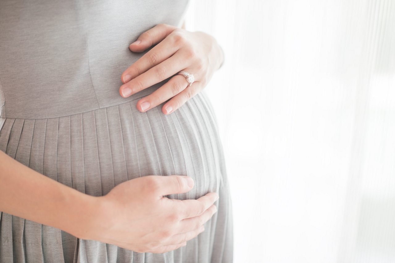 Frau hält ihren Babybauch