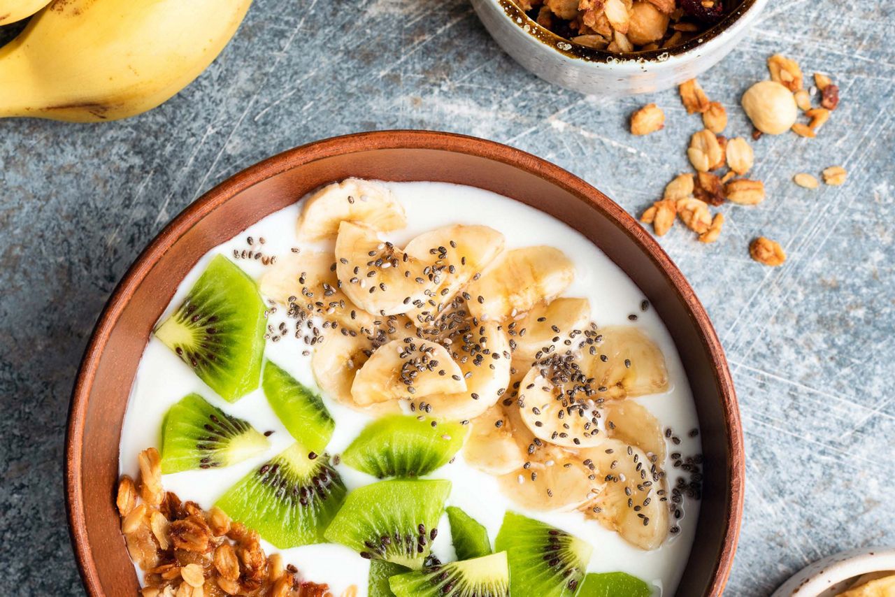 kiwi et banane coupés en rondelles dans un bol avec du yaourt