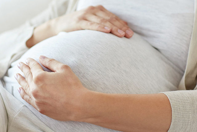mujer embarazada con blusa gris