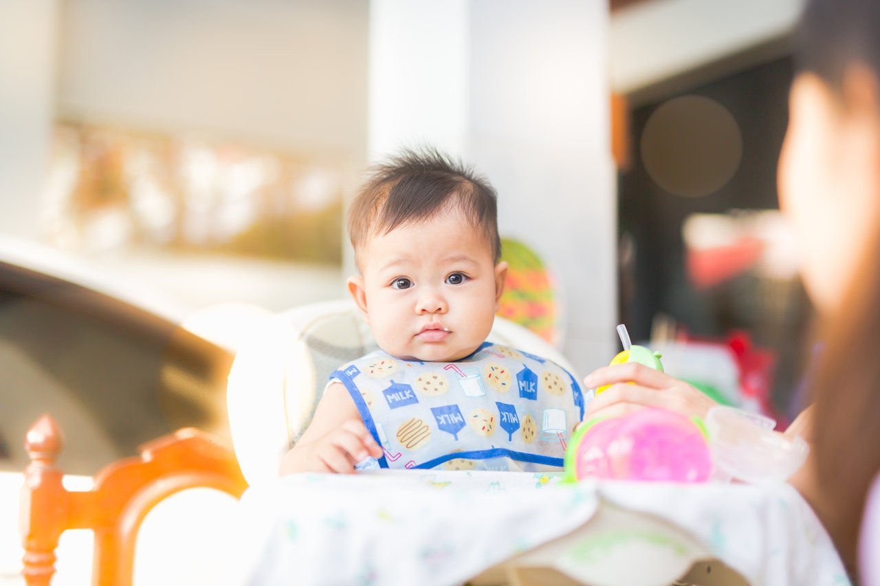 baby eating in highchair