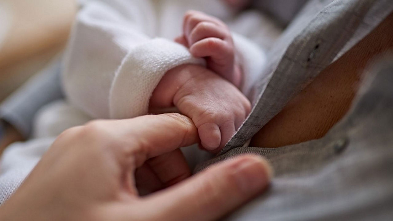Conexión entre madre y bebé, tomados de la mano