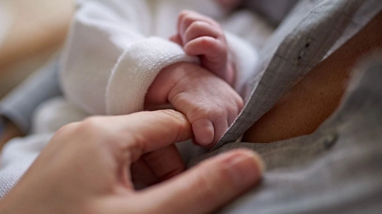 Baby holding finger